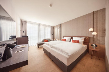 Moderne hotelkamer in ATLANTIC Hotel Münster met een tweepersoonsbed en een bureau