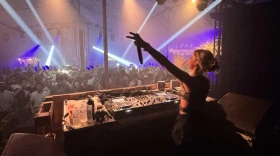 DJ JoyLiana tijdens een optreden achter de draaitafel voor een dansende menigte 