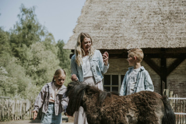 Moeder en kinderen bij pony in kinderboerderij Vakantiepark Dierenbos