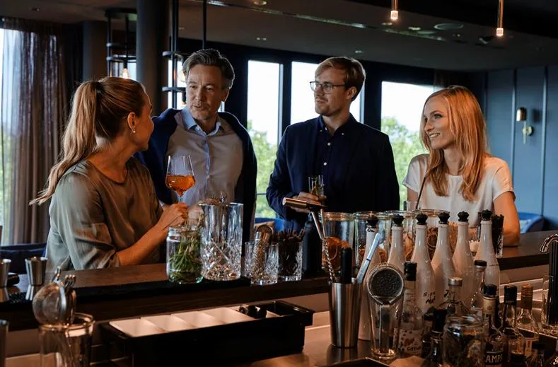 Gasten genieten van drankjes aan de luxe bar in ATLANTIC Hotel Münster