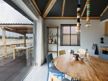 Eetkamer in Afrikaanse luxe lodge met uitzicht op terras en savanne in Safari Resort Beekse Bergen