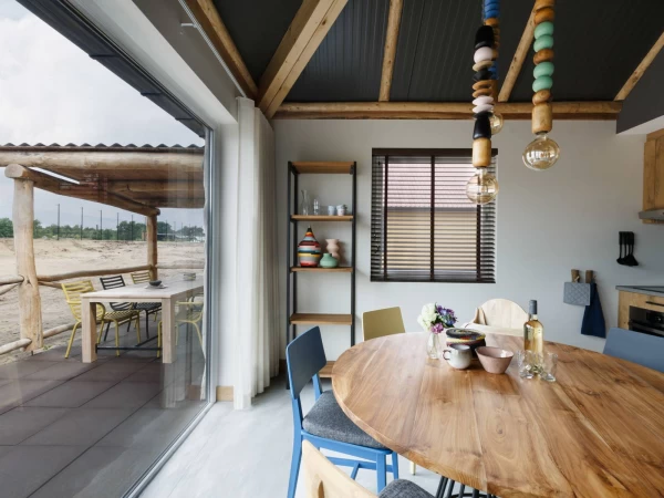 Eetkamer in Afrikaanse luxe lodge met uitzicht op terras en savanne in Safari Resort Beekse Bergen