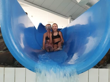 Kinderen glijden van grote glijbaan bij Recreatiepark De leistert.