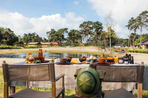 Gedekte ontbijttafel voor een unieke overnachting tussen de wilde dieren met uitzicht op de savanne van Safari Resort Beekse Bergen