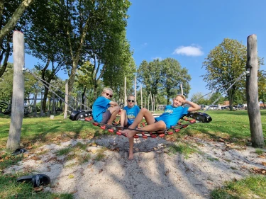 Kinderen ontspannen in hangnet bij speeltuin van vakantiepark De Leistert