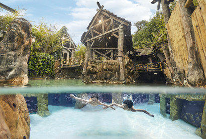 Twee mensen zwemmen onder water en kijken naar tropische vissen in het Aziatisch Vissersdorp in de Aqua Mundo van Center Parcs Erperheide.